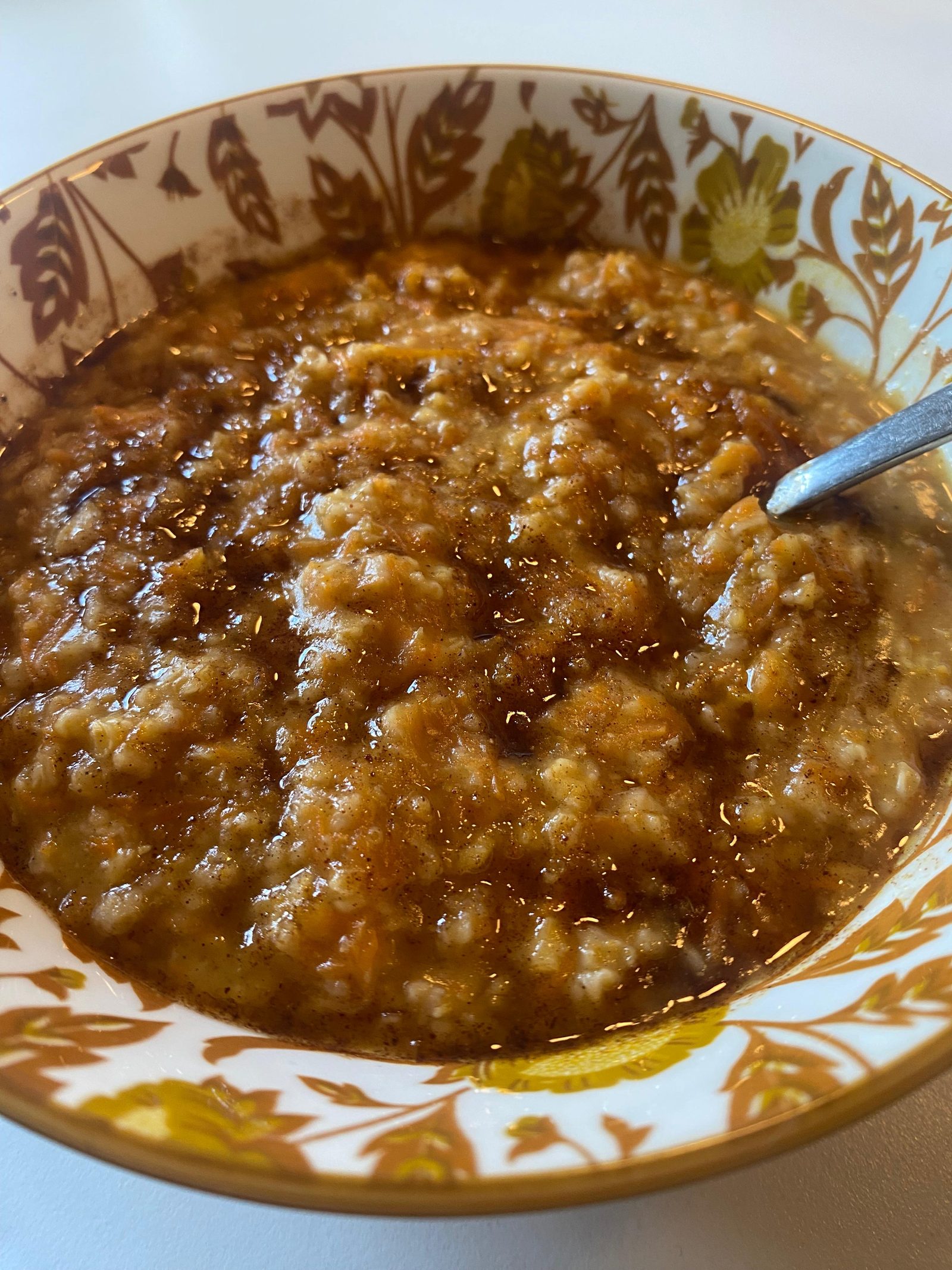 Een diep bord met warme Ayurvedische rijstepap, bestrooid met kaneel en glanzend van de ghee