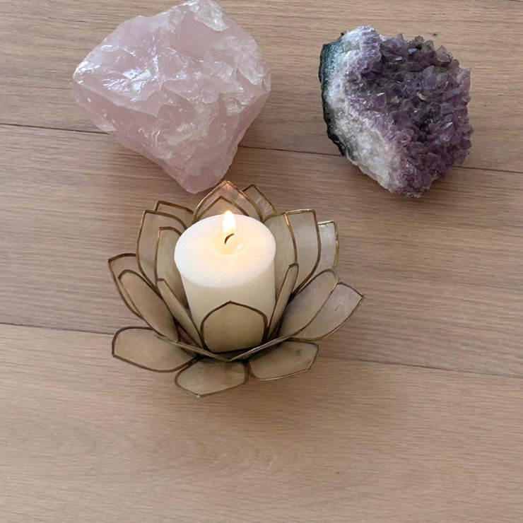 een lotusbloem met een brandend kaarje omgeven door een amethist en een rozequarts
