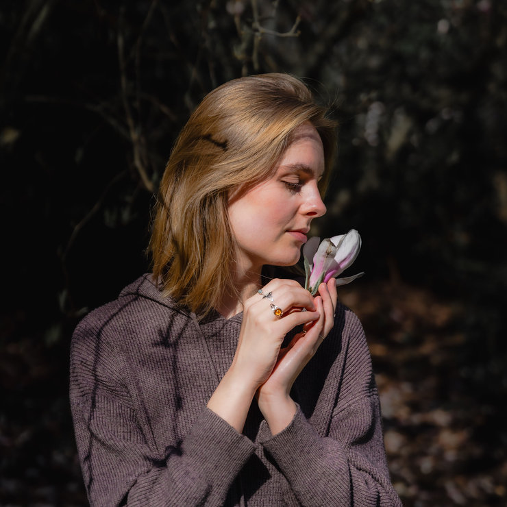 Vrouw in de natuur met bloem in haar handen