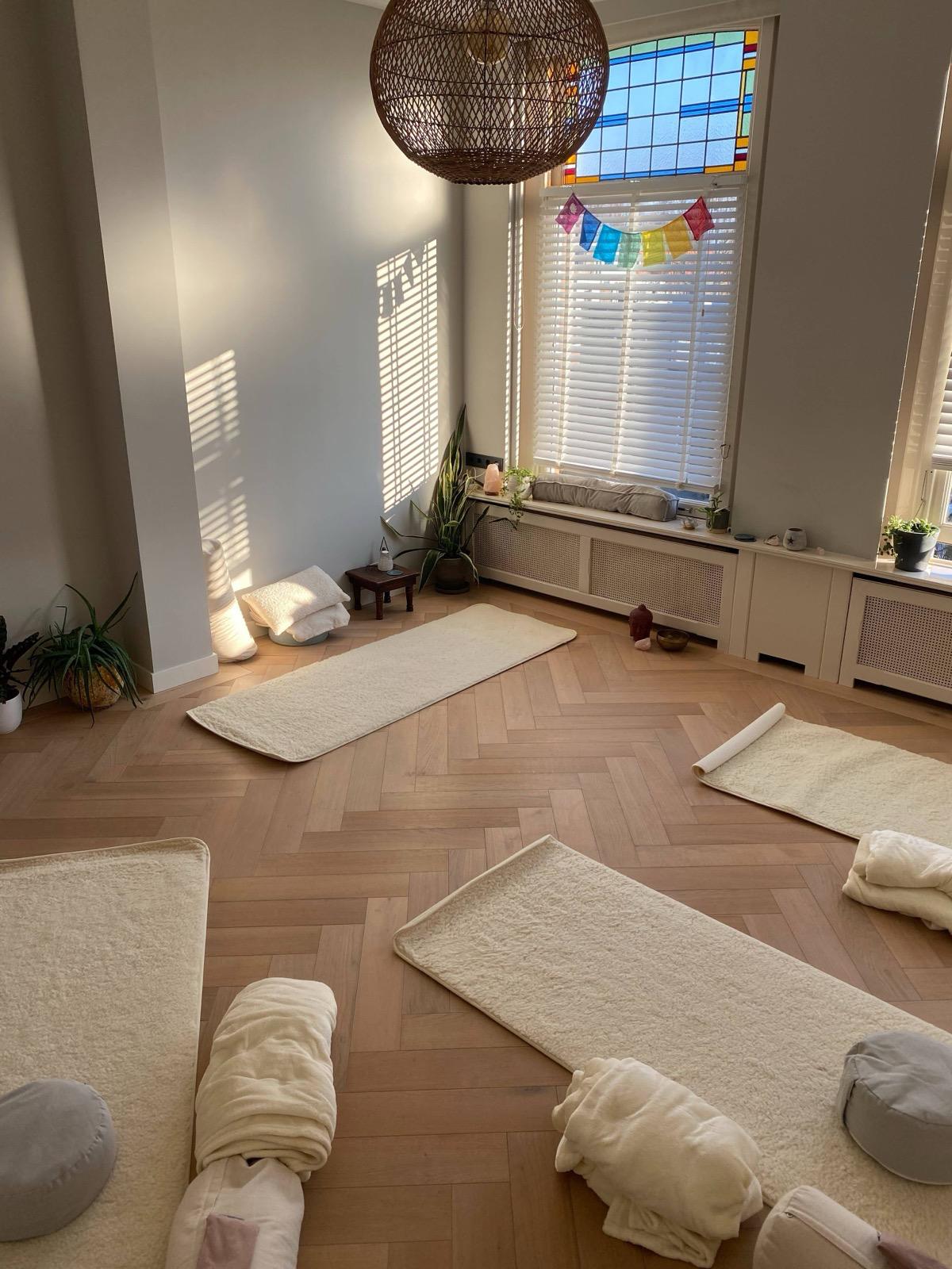 De yogaruimte van Studio Rose Moon in Breda, met wollen matten in zacht zonlicht